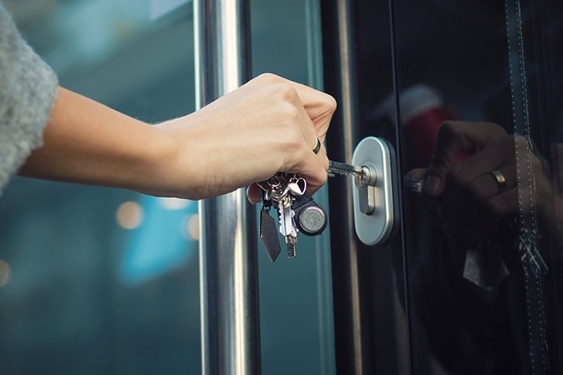 Massachusetts School Security. Photo of a person using a key to get into a door.